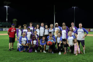 Group on baseball field at night.