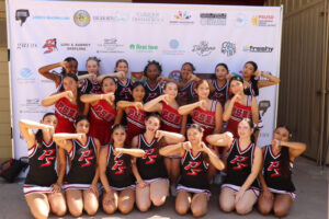 Cheerleading team posing in front of banner.