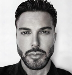 Man with beard and slicked-back hair.
